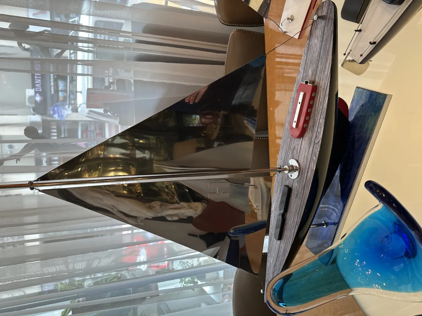 Antikes Schiff des Designers mit reflektierenden Segeln und eleganten Formen in einem Innenraum.