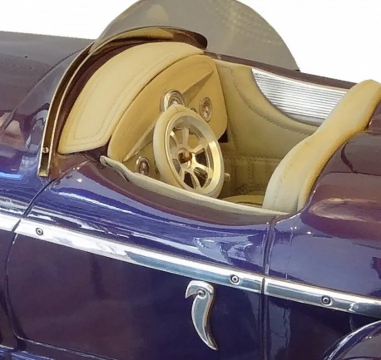 デザイナー・マルセロ・ペーニャの古い車の内装、クリーム色のディテールと銀色のハンドル付き。