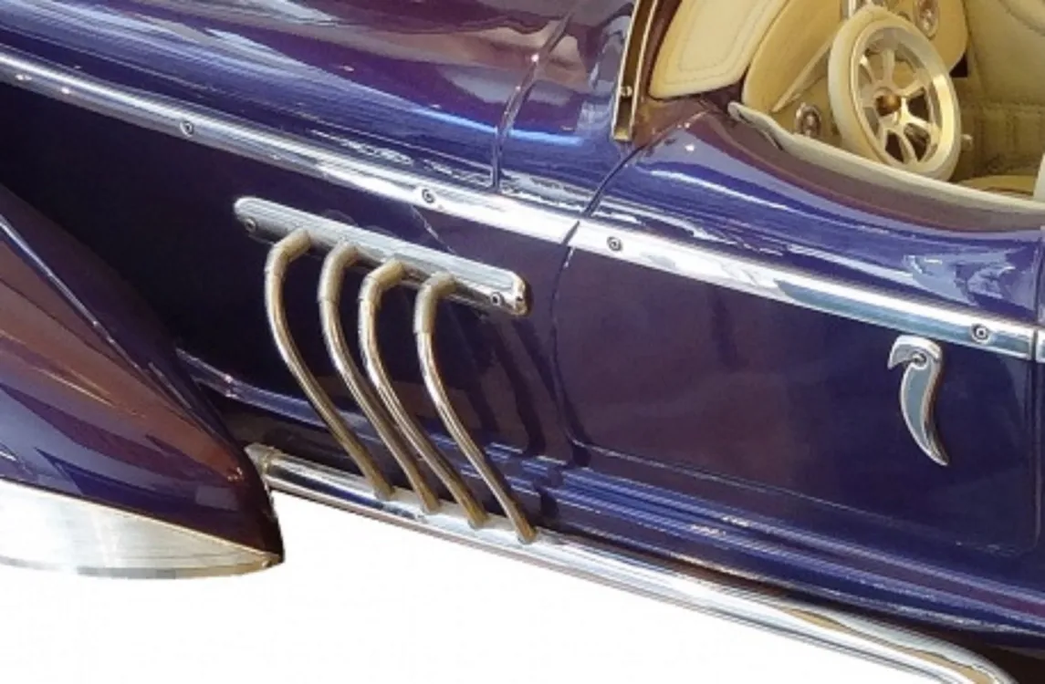 Antique designer car by Marcelo Peña in purple with detailed features.