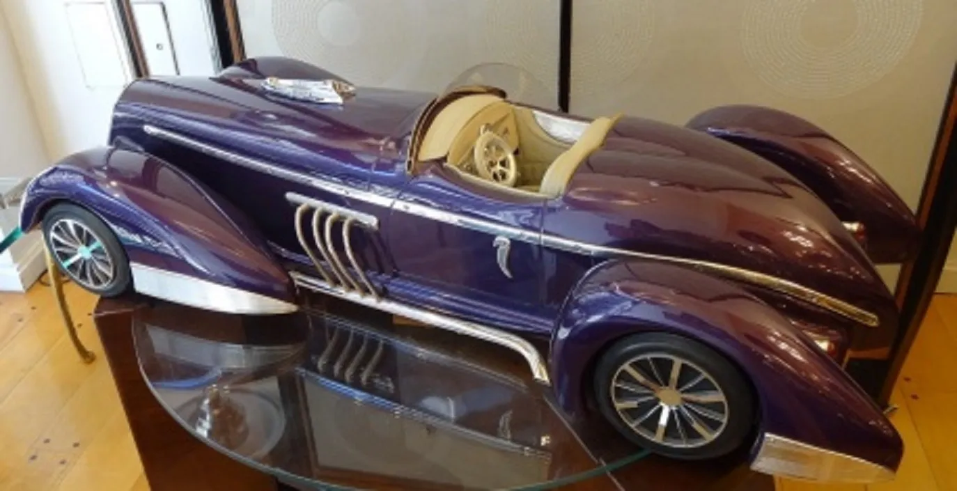 Carro antigo do designer Marcelo Peña, cor roxa, elegante e curvado.