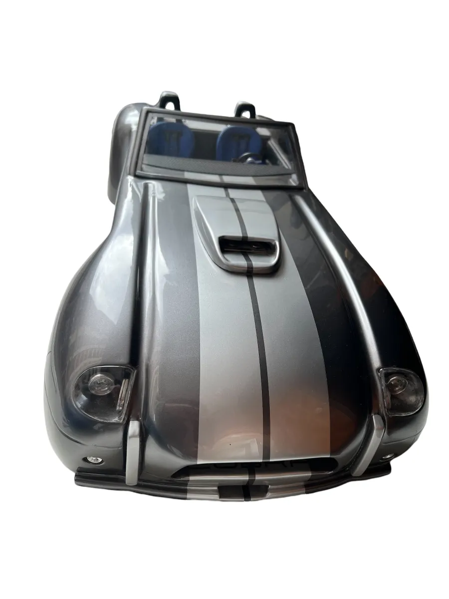 Antique designer car by Marcelo Peña, featuring grey and black details, set in an artistic background.