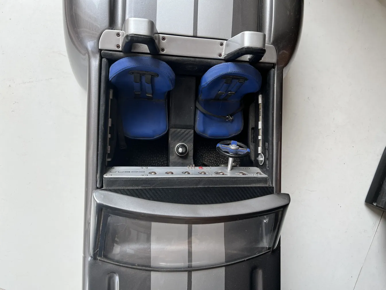 डिज़ाइनर की पुरानी कार का ऊपरी दृश्य, जिसमें नीली सीटें हैं