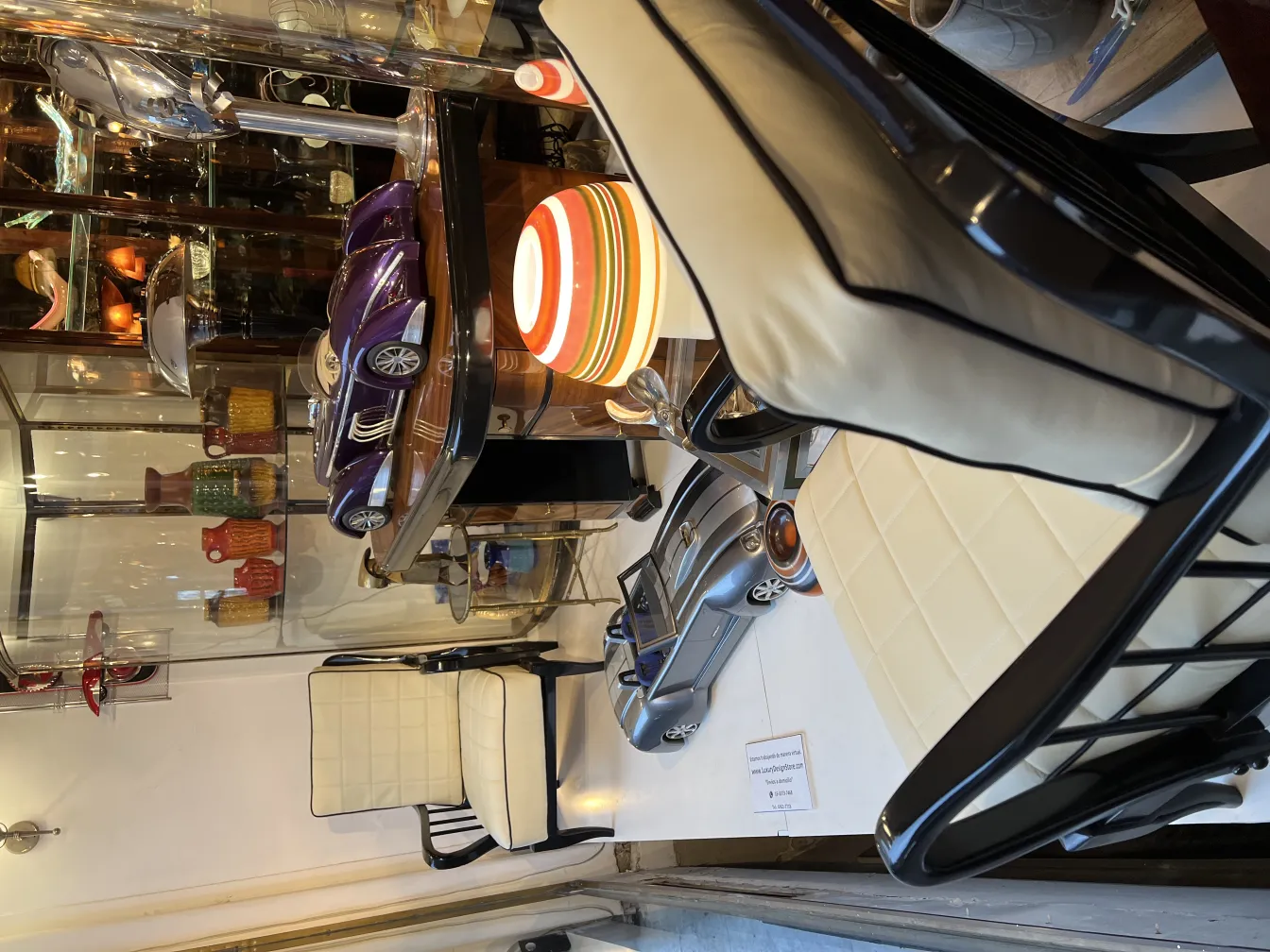 Voiture antique du designer Marcelo Peña, exposée dans une vitrine, entourée de décorations colorées