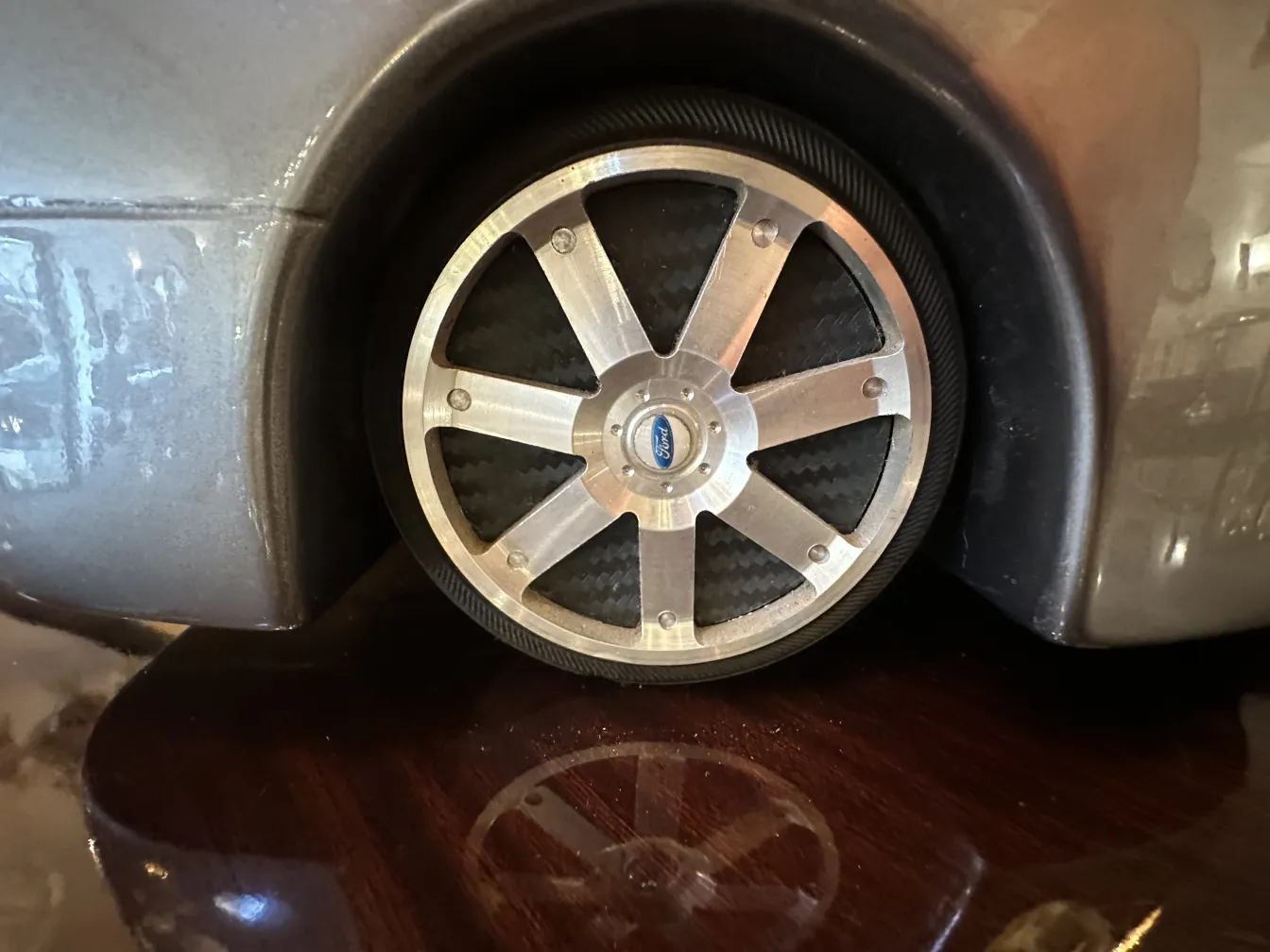 Nahaufnahme eines antiken Designerautos mit modernen Rädern, die seine Umgebung reflektieren.