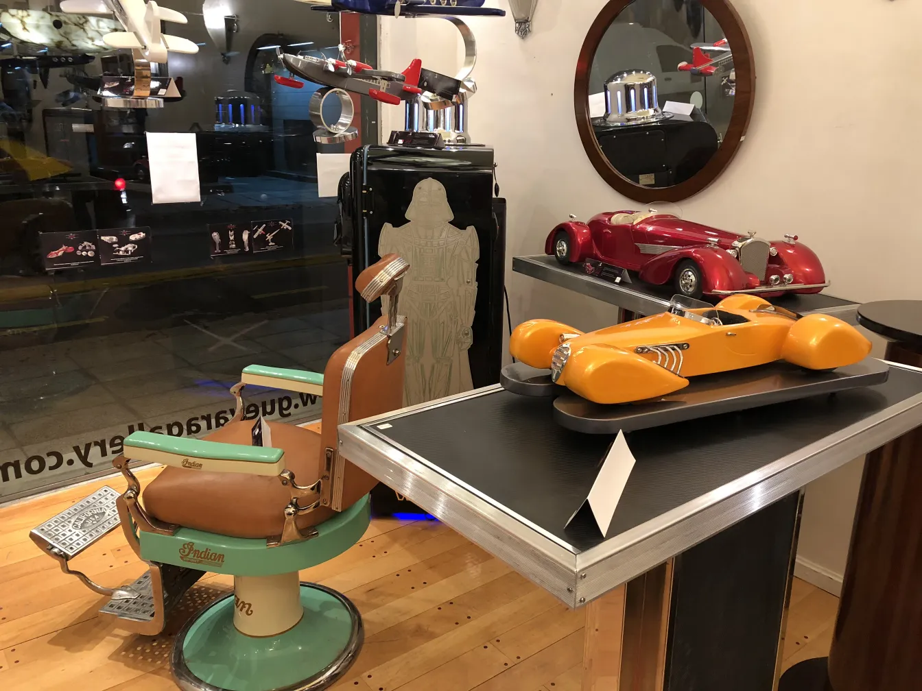 डिज़ाइनर मार्क्सेलो पेना के प्राचीन हवाई जहाज़ एक सजावटी सेटिंग में अन्य प्राचीन वस्तुओं के साथ प्रदर्शित होते हैं।