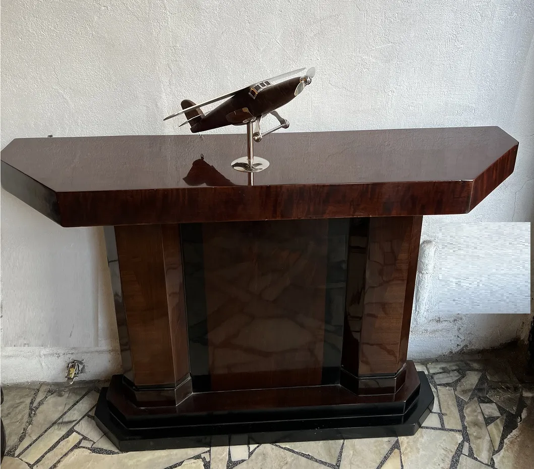 Escultura de avião antigo do designer Marcelo Peña em uma mesa estilosa.