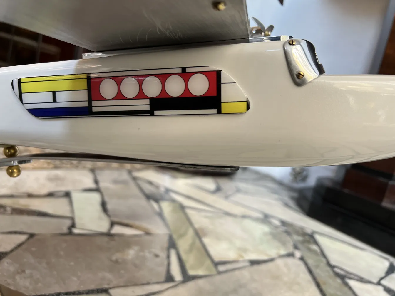 Detalle de aviones antiguos del diseñador Marcelo Peña con colores vivos en un fondo de piedra.