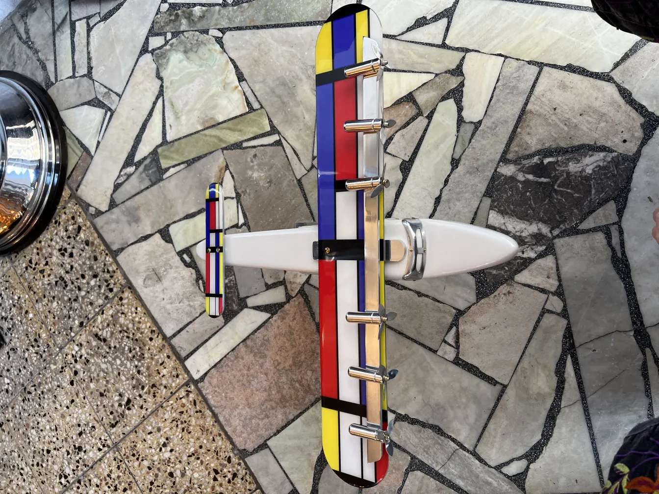 Modelo antigo de avião do designer Marcelo Peña com cores vibrantes.