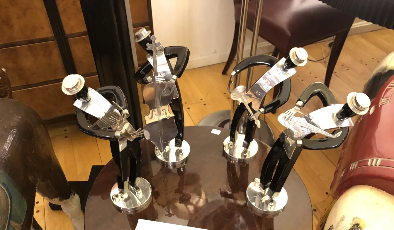 esculturas antiguas de una banda de música en una mesa