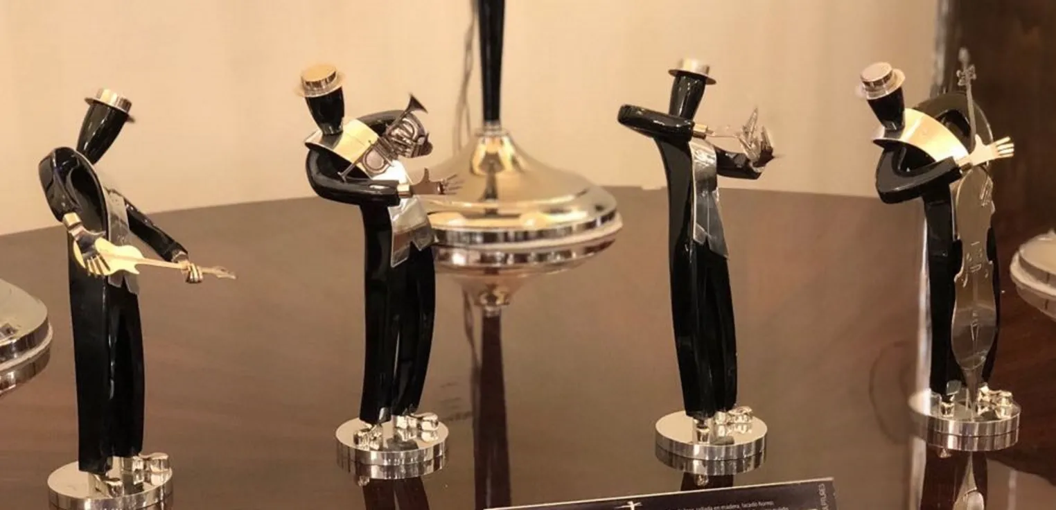 Antike Skulpturen einer Musikband, Figur mit Gitarre und anderen Instrumenten, elegante Umgebung.