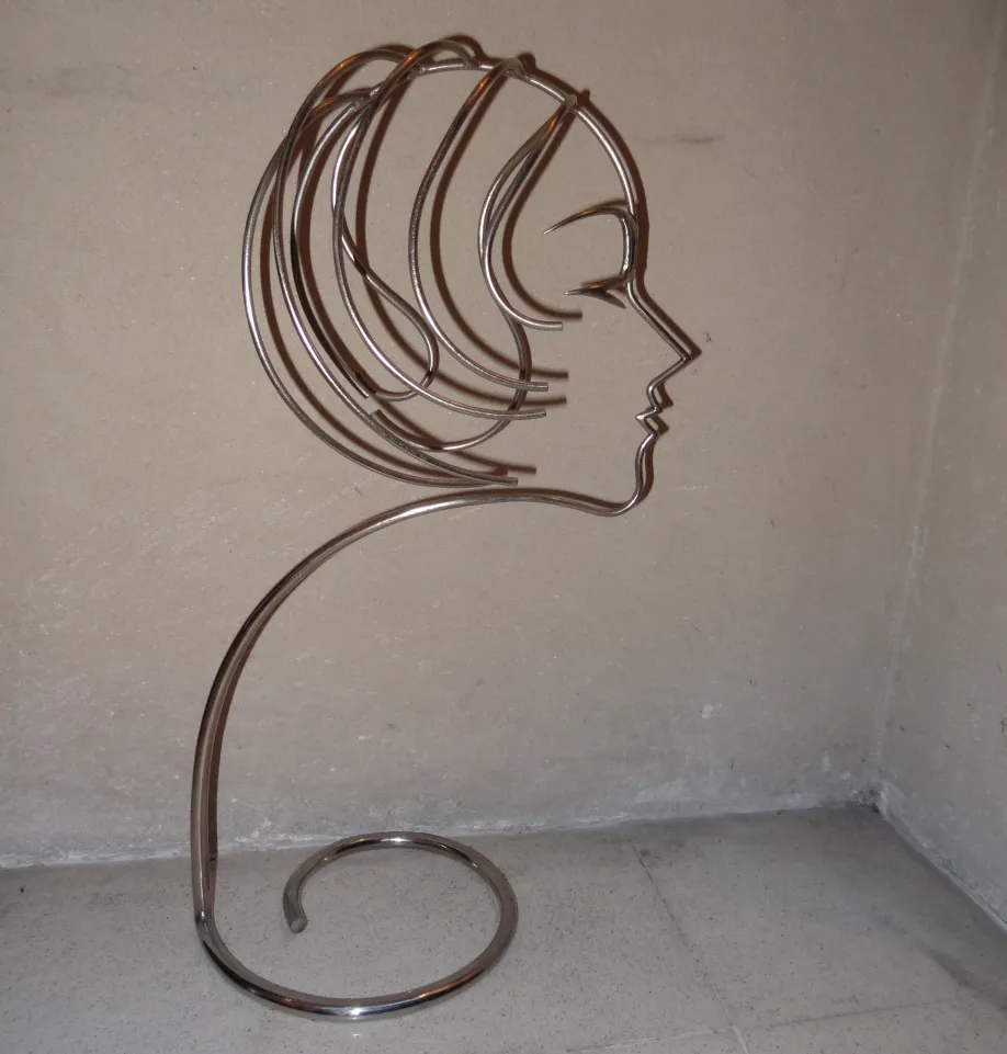antique sculpture in the shape of a female face, curvy and elegant lines
