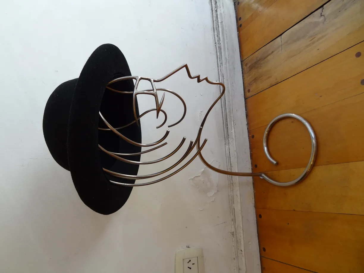 escultura que apresenta um design de chapéu preto com um suporte elegante