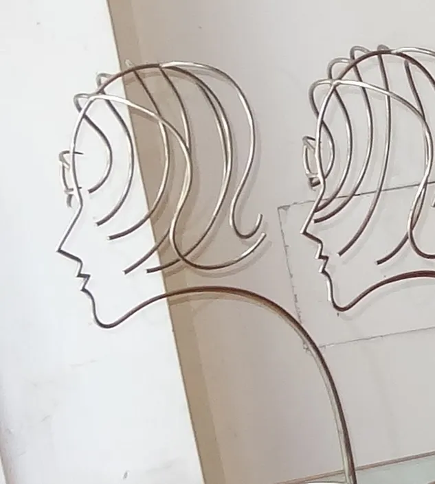 escultura moderna de silhuetas humanas de perfil, fundo claro