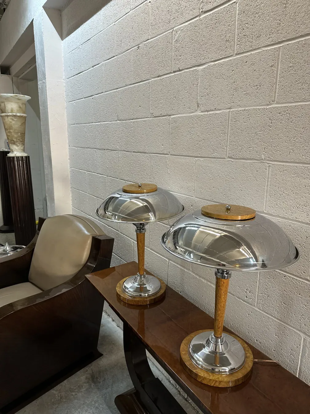 Consola antigua con lámparas modernas en un ambiente decorativo.