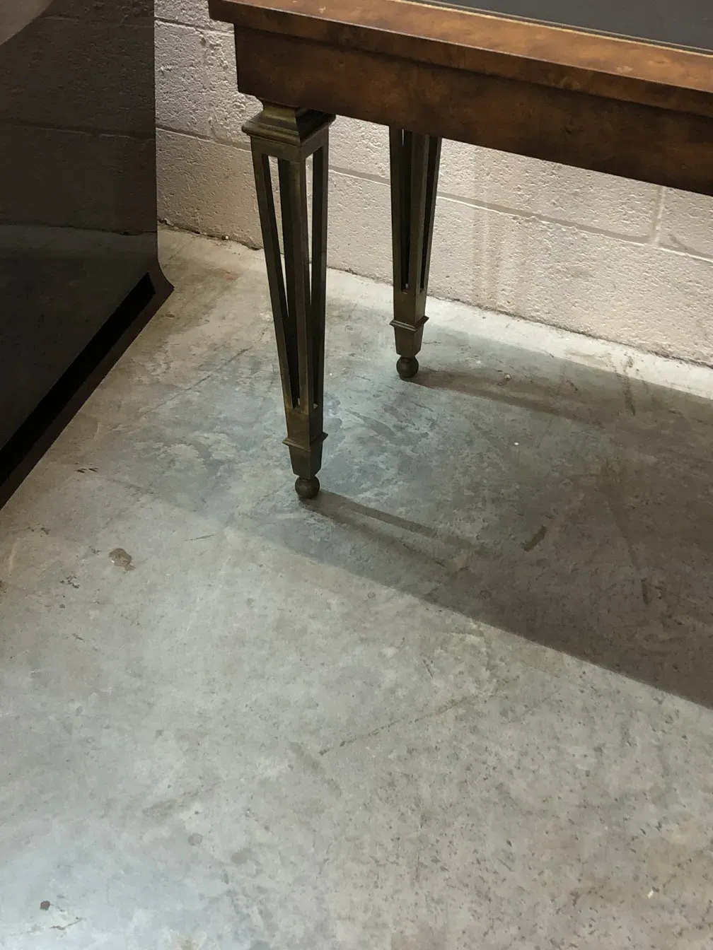 vue d'une ancienne console avec des pieds décoratifs, dans un environnement simple