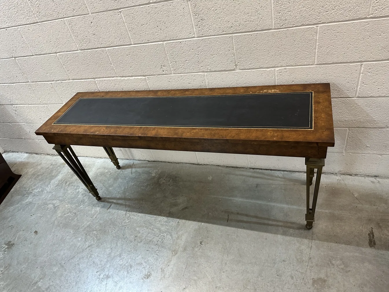 Mesa de console antiga com topo preto e pernas metálicas