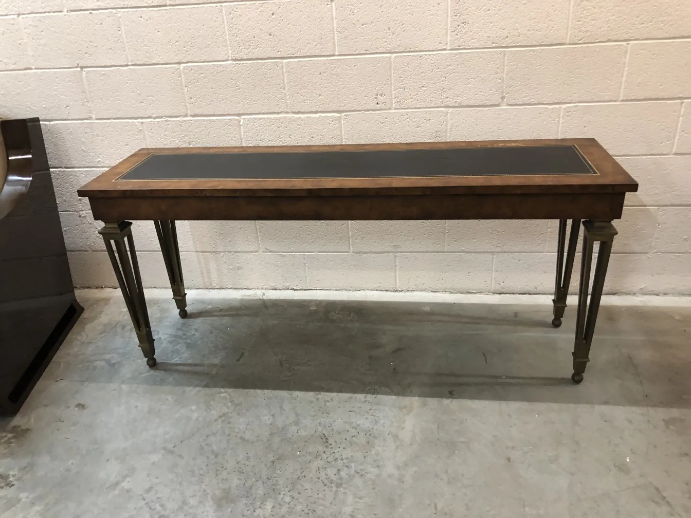 ancienne console avec dessus sombre et pieds dorés