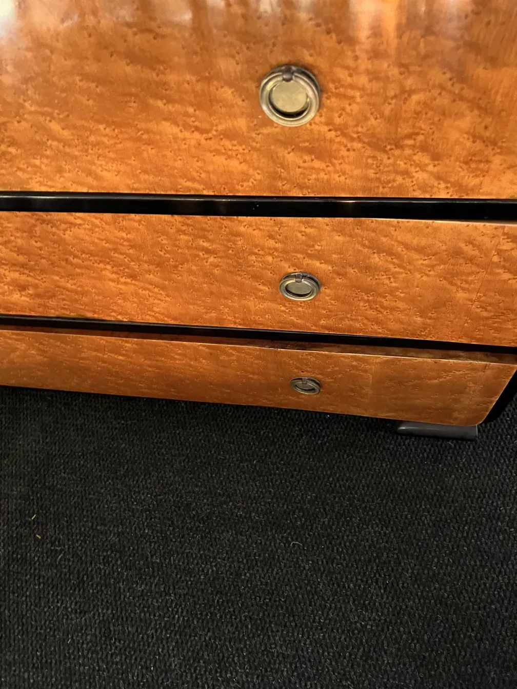 Commode ancienne présentant des détails décoratifs en bois.