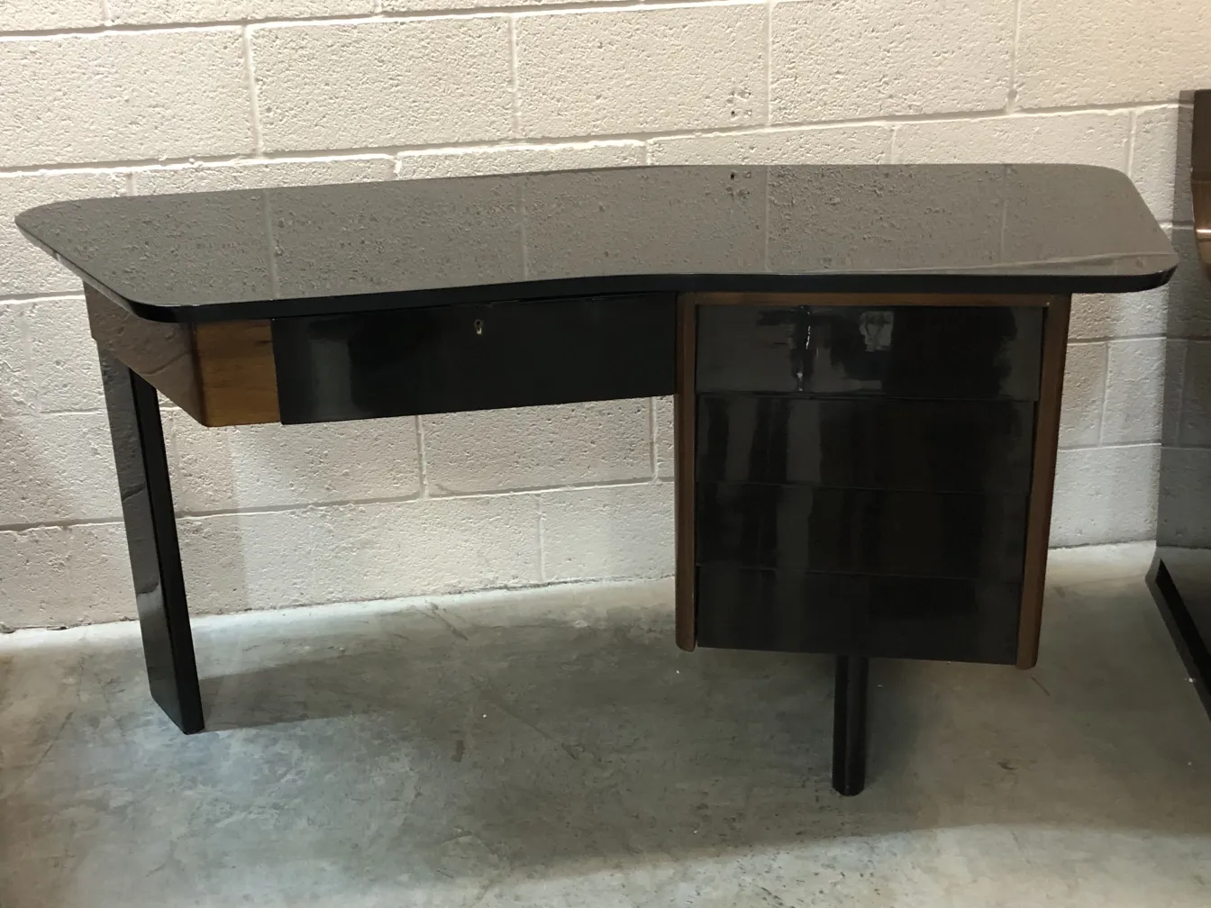 우아한 마감과 튼튼한 다리를 가진 고급 책상이 중립적인 환경에 있습니다