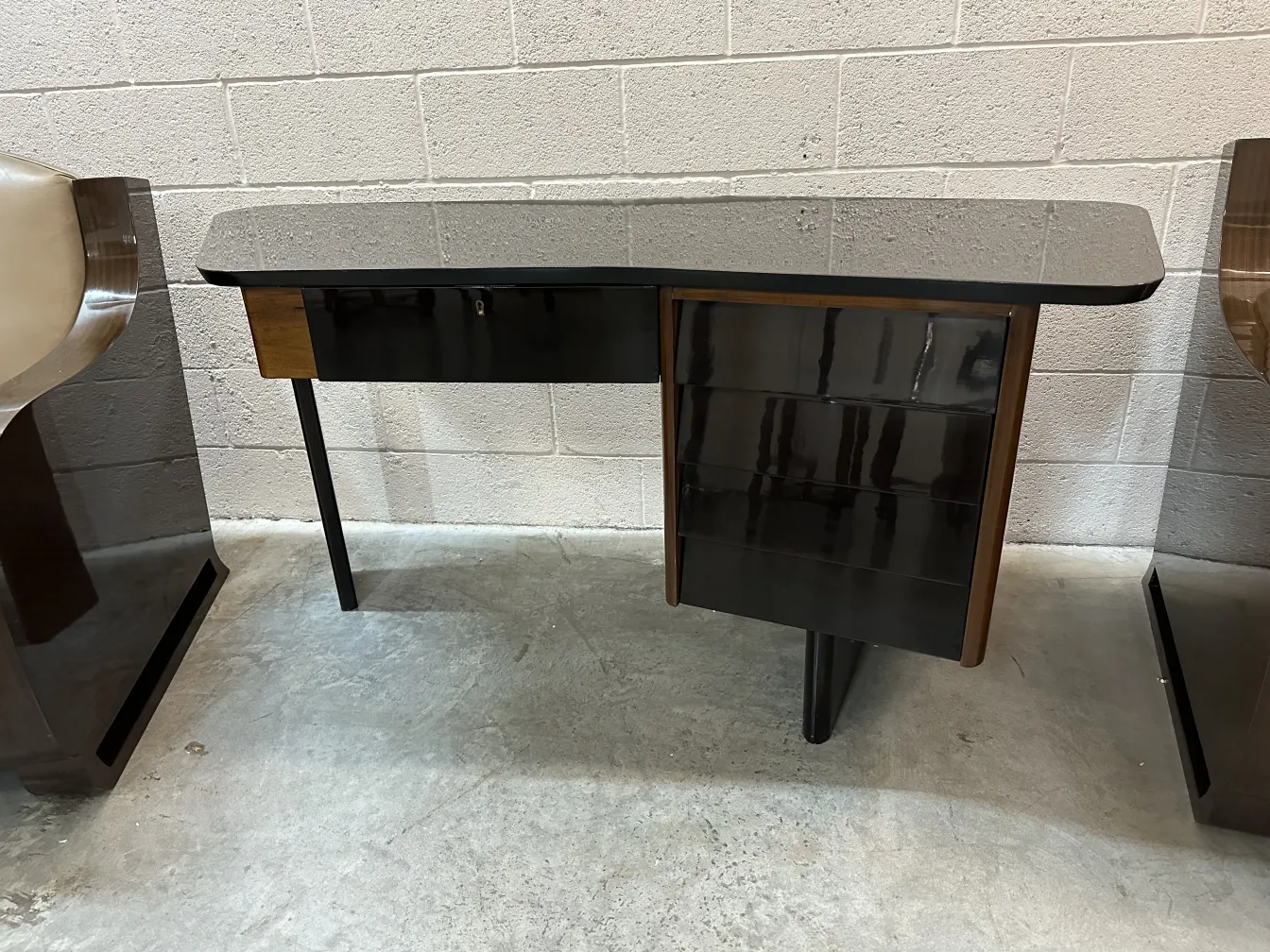 古典书桌光滑的表面和深色饰面，周围有椅子