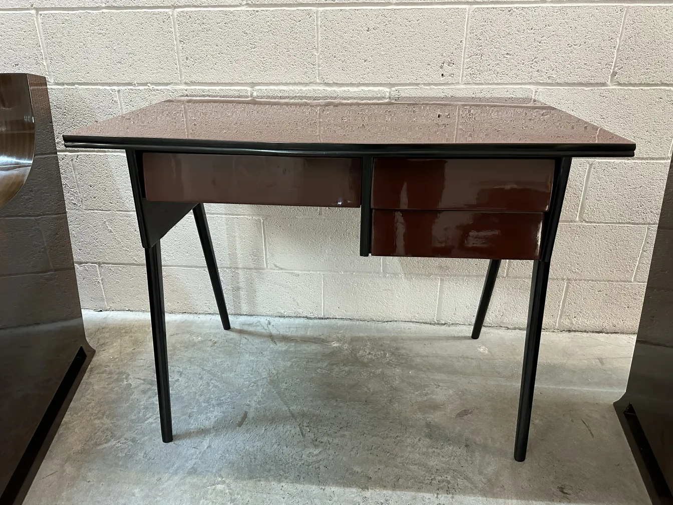 antik Schreibtisch mit zwei Schubladen in einem minimalistischen Umfeld.