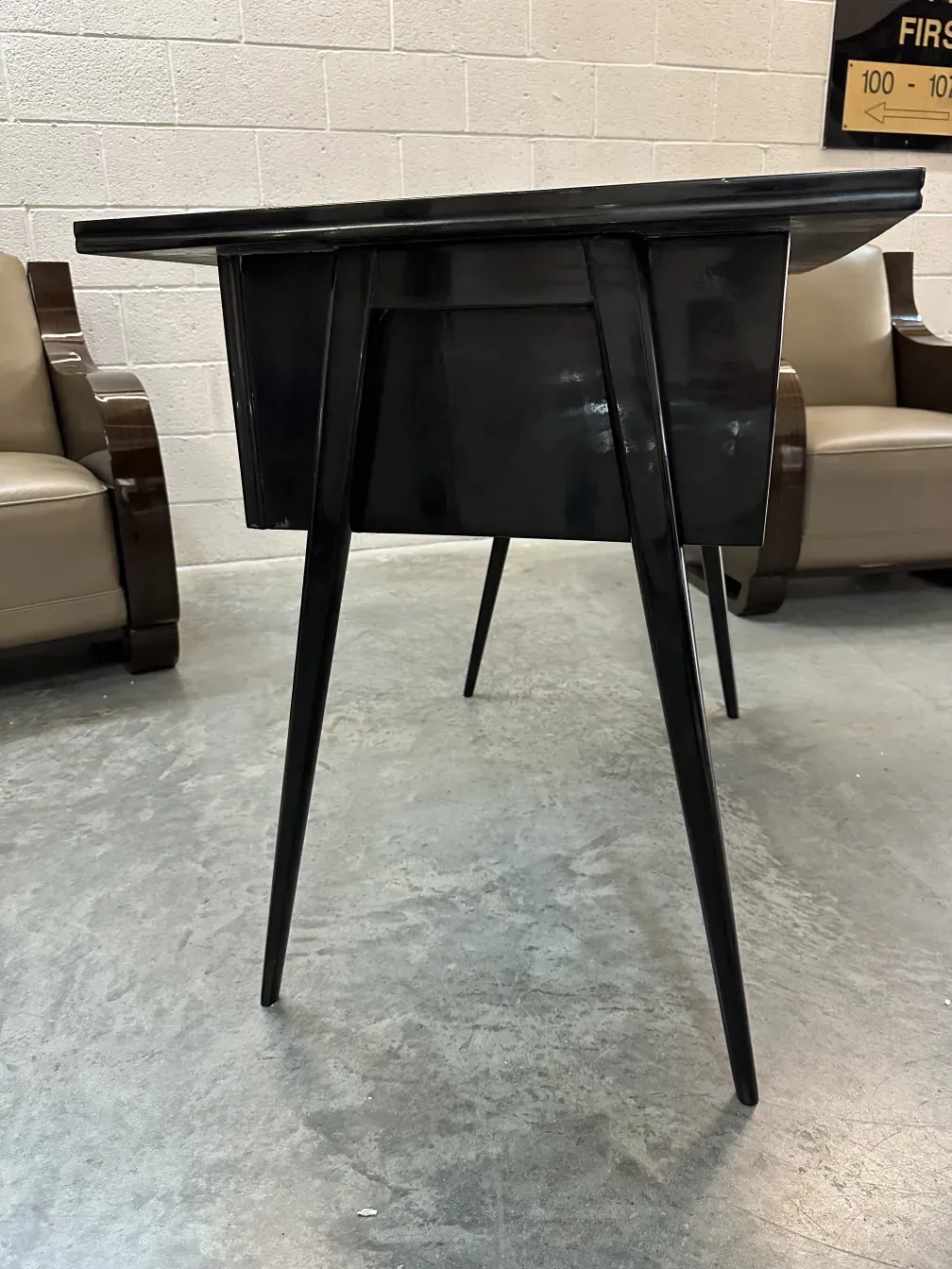 bureau ancien noir avec des pattes fines, fond gris