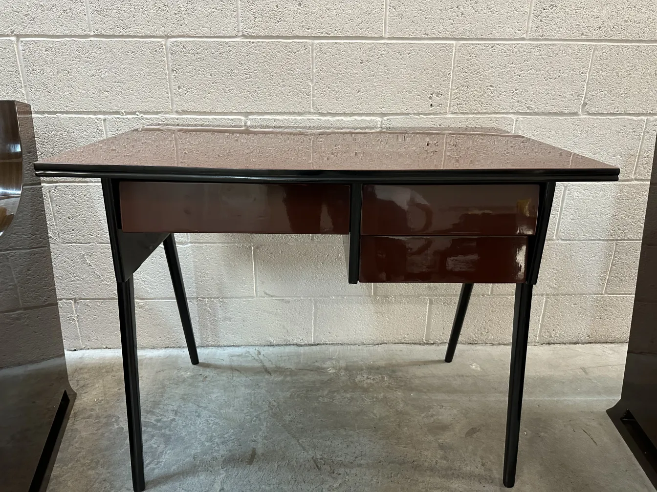 antiker schreibtisch mit glänzender oberfläche und schrägen beinen