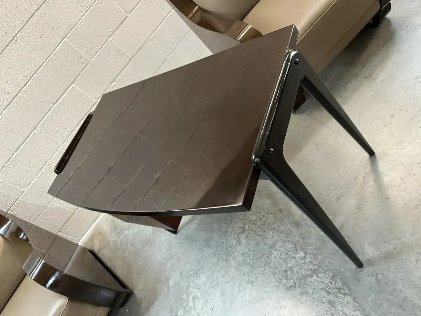 Antiker Schreibtisch mit glatter Oberfläche und dünnen Beinen in einem modernen Ambiente.