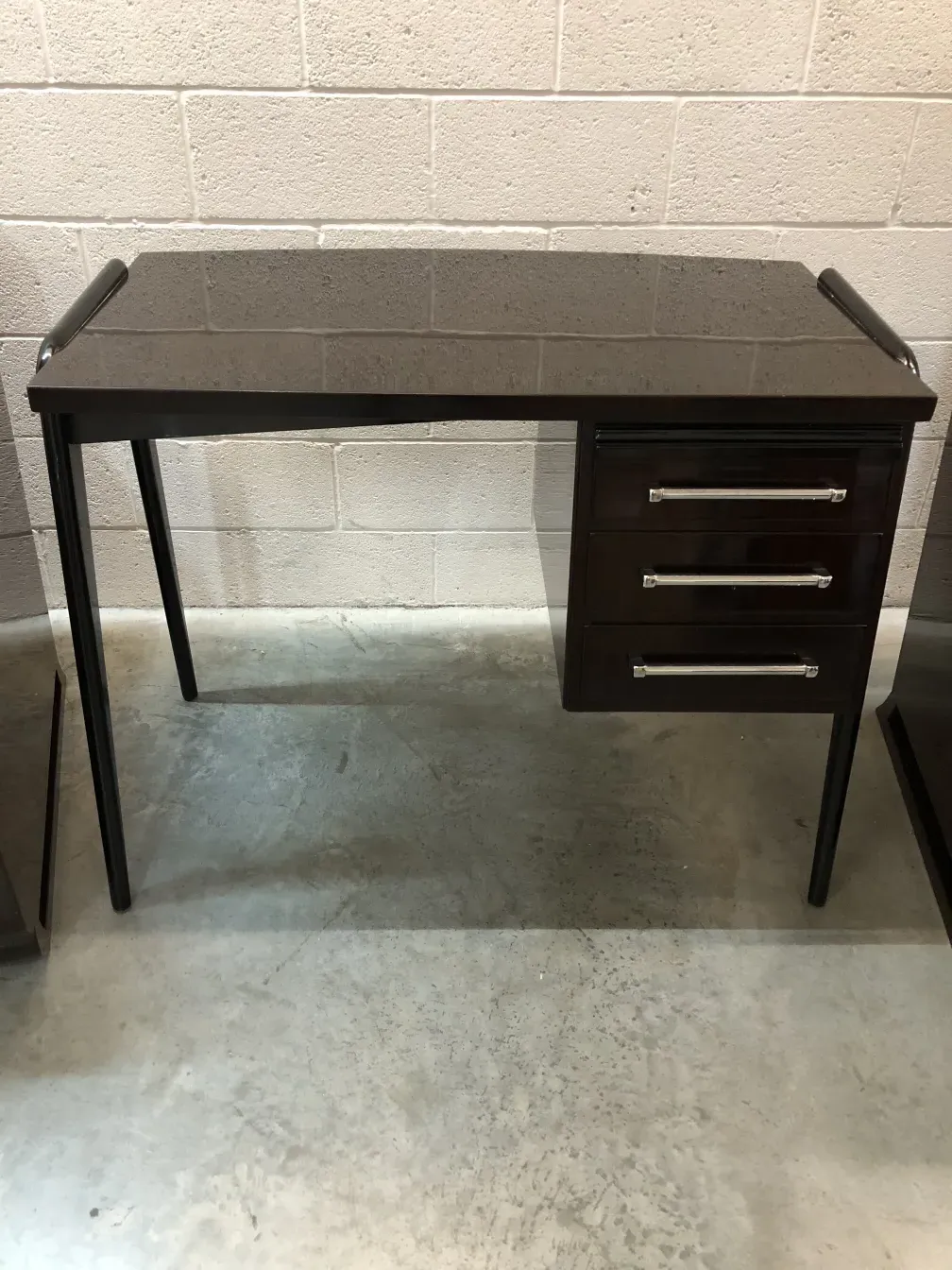 mesa antiga com três gavetas em um ambiente neutro