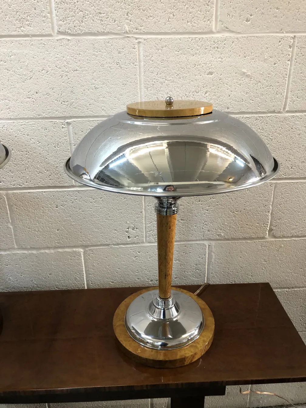 Deux lampes de table anciennes avec base ronde et design élégant, sur une surface en bois.