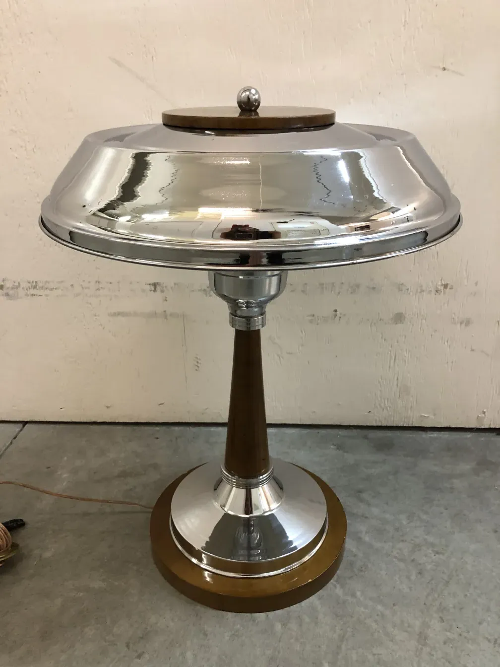 2 lâmpadas de mesa antigas com base em forma de copo e detalhes refinados em um ambiente simples.