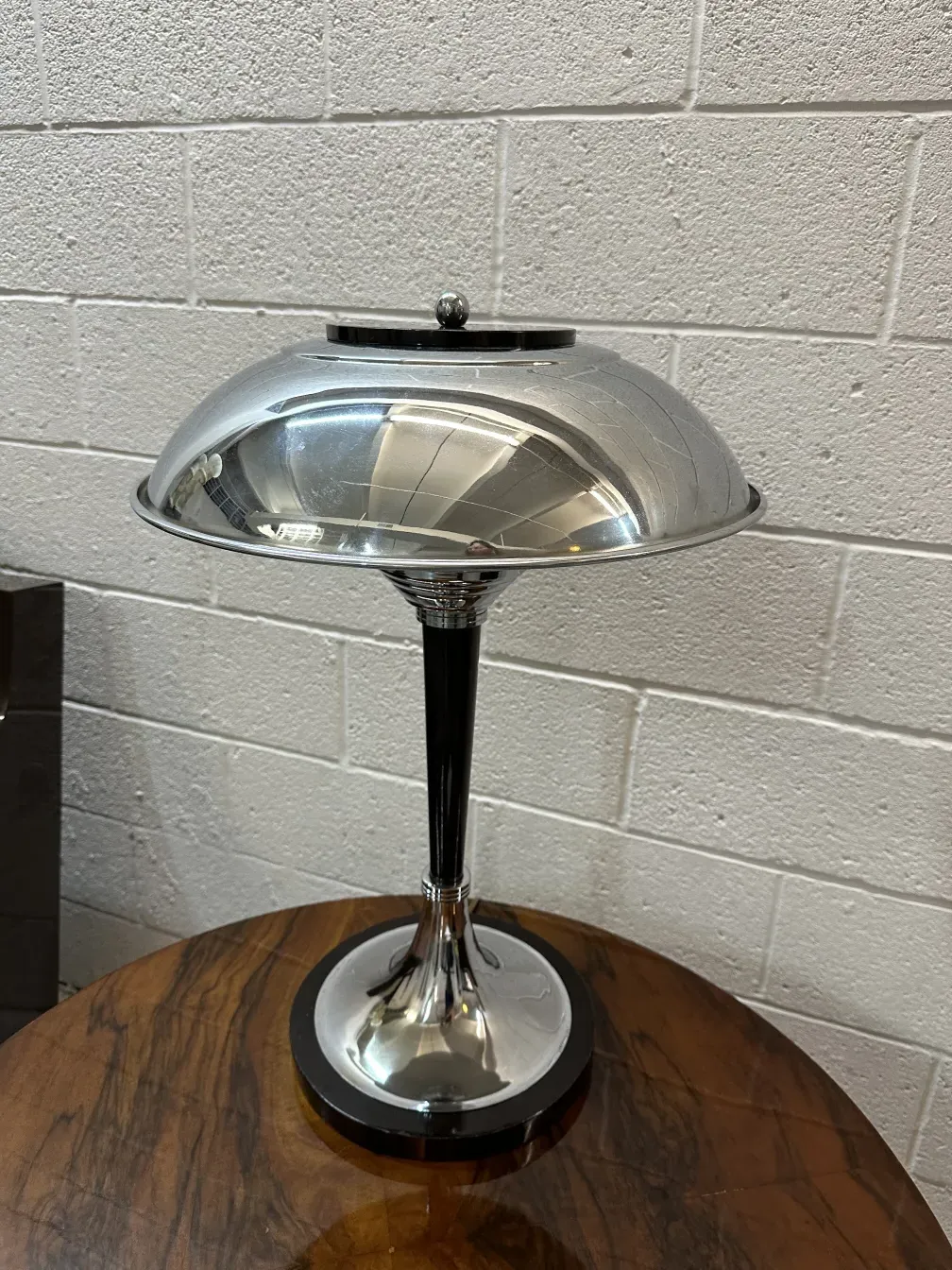 Deux lampes de table anciennes avec un design élégant, l'une métallique et brillante, dans un cadre chaleureux.