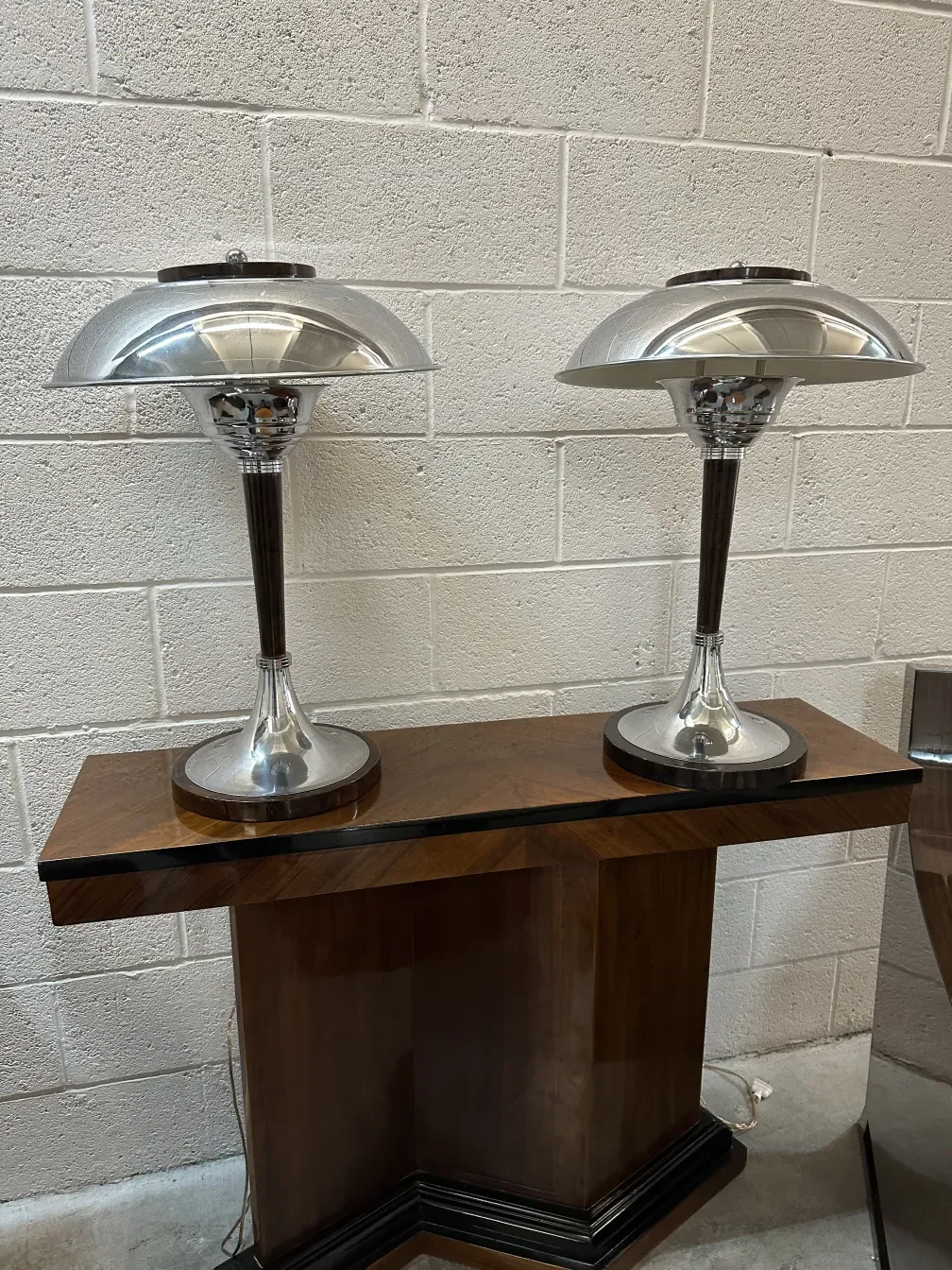 two antique table lamps with elegant bases and round shades, plain background