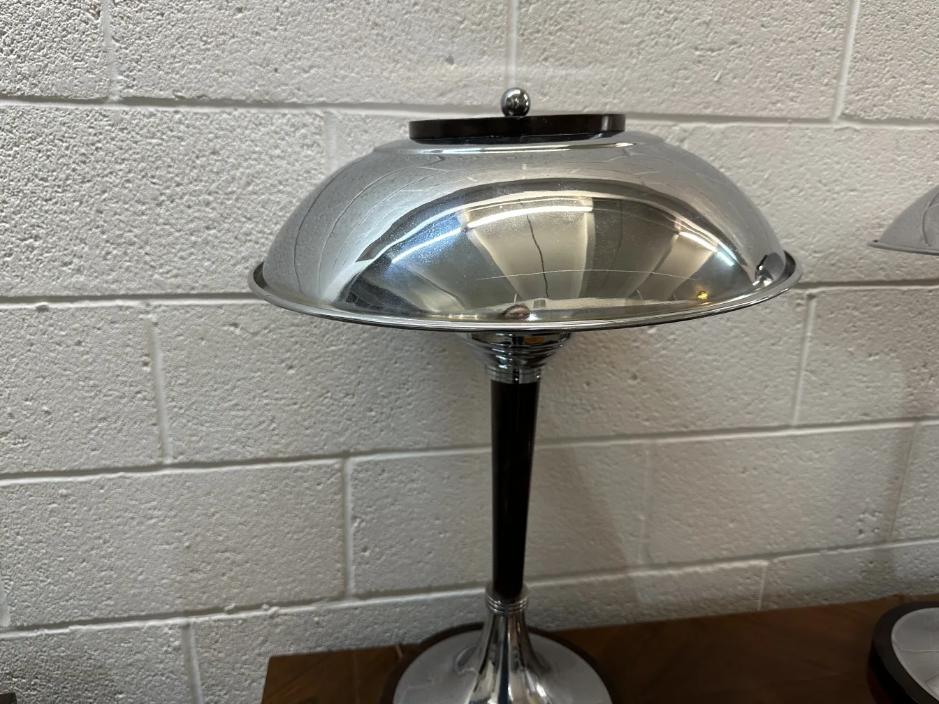 2 lampadas de mesa antigas com bases elegantes e telas brilhantes, ambientadas em um espaço moderno.