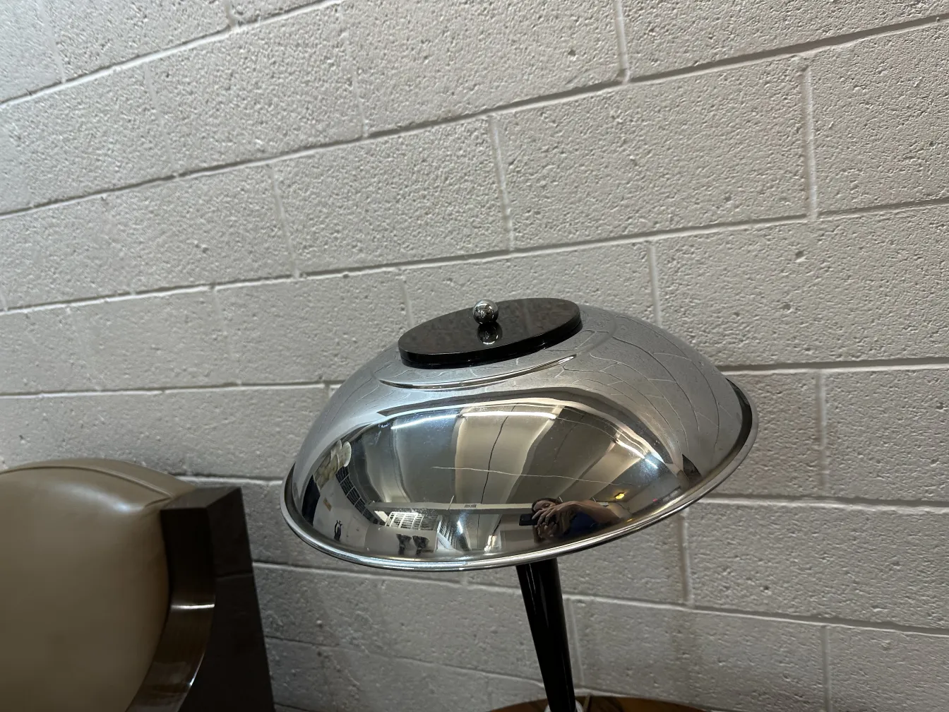 dos lámparas de mesa antiguas con base brillante y estilo clásico, en un ambiente neutro, junto a una silla