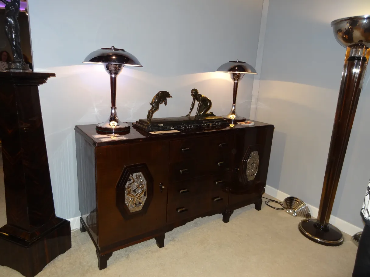 two antique table lamps with shiny bases illuminating a dark furniture