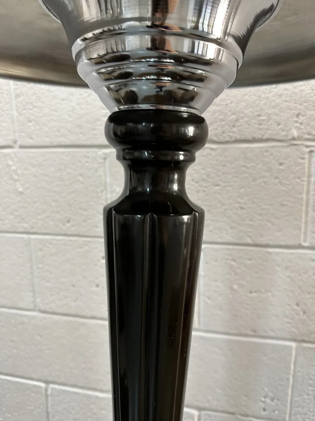 Details of 2 antique table lamps with a shiny finish in the background.