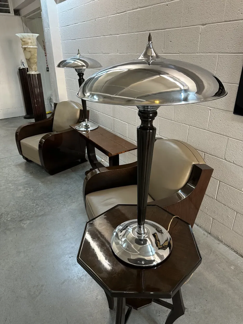 Dos lámparas de mesa antiguas con bases elegantes y pantallas brillantes, en una habitación con muebles sofisticados.