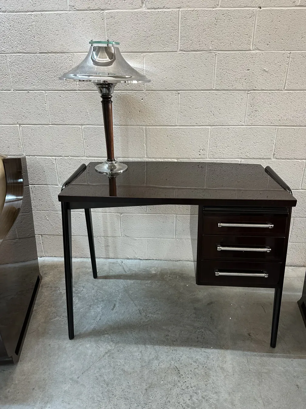 Antigua lámpara de mesa con base de cristal en un ambiente moderno.