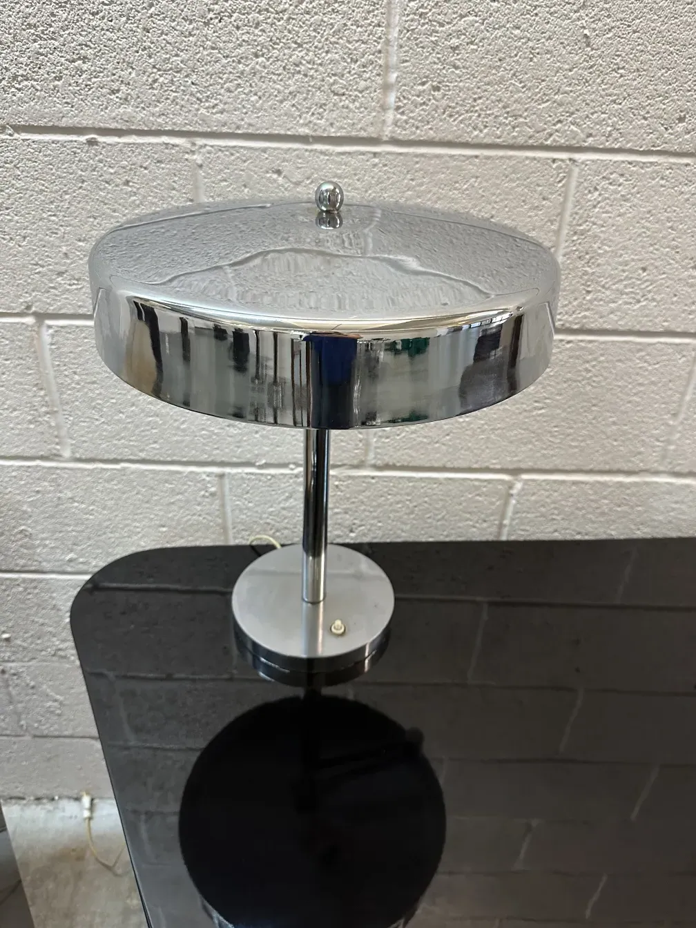 luminaria de mesa antiga com base redonda prateada em um ambiente elegante