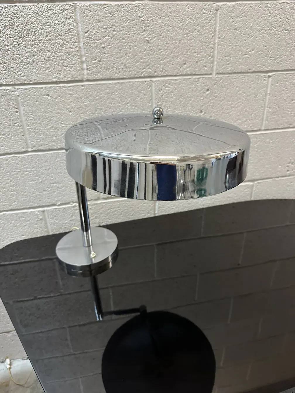 Luminária de mesa antiga com base redonda e luz suave, ideal para ambientes aconchegantes.