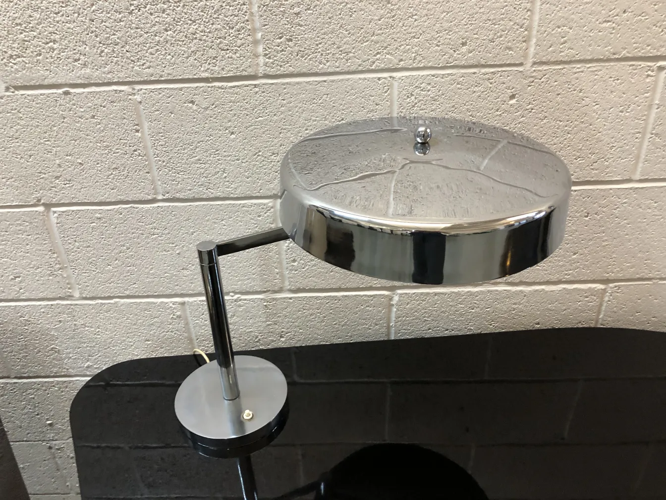 Luminária de mesa antiga com base redonda, elegante e funcional em um ambiente moderno.