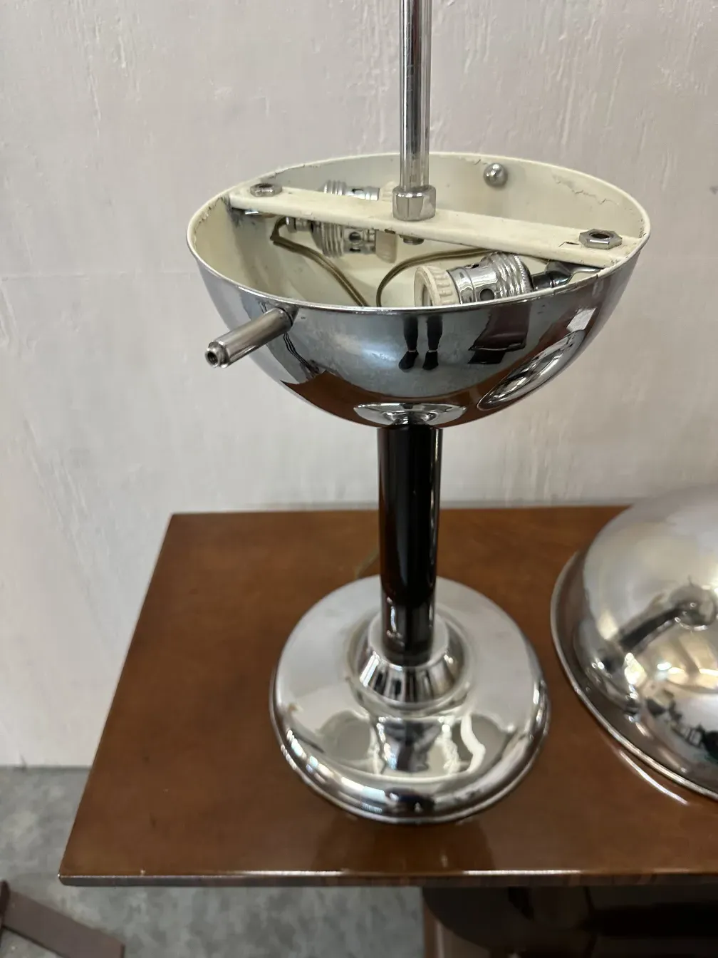 Lámpara de mesa antigua con base brillante en un entorno decorativo.