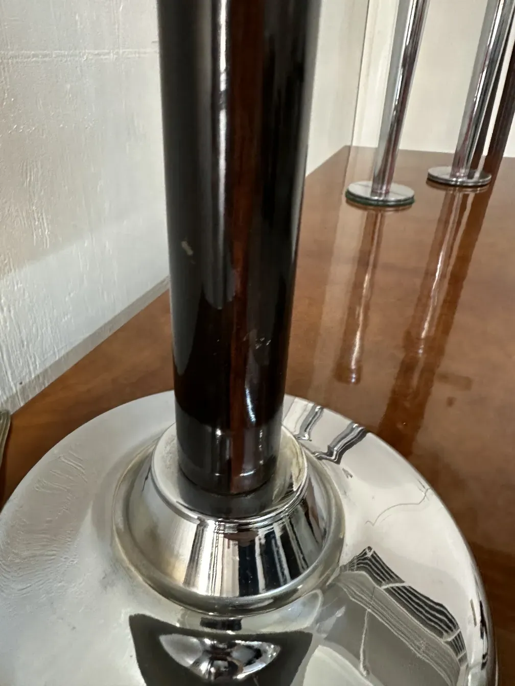 Details einer antiken Tischlampe mit glänzendem Fuß, neutraler Hintergrund