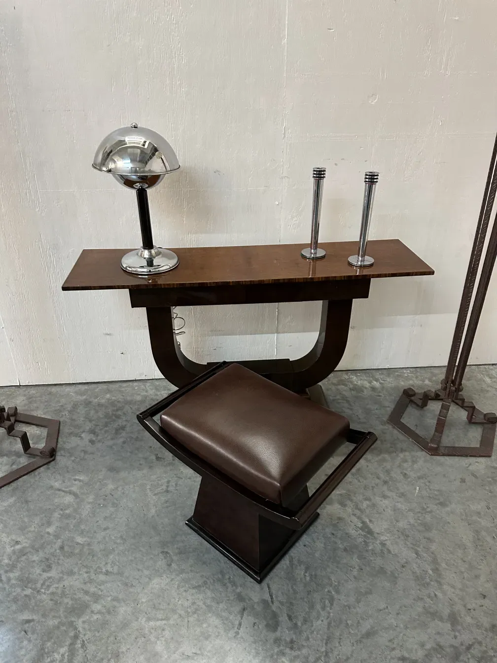 lampada da tavolo antica con finitura lucida e design aerodinamico, accanto a una sedia e un tavolo