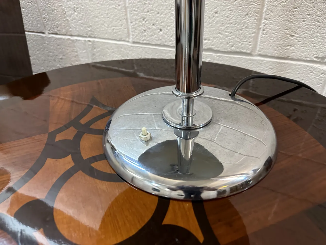 detalhes de uma antiga luminária de mesa com base brilhante em uma mesa de design elegante. Mostra um ambiente acolhedor.