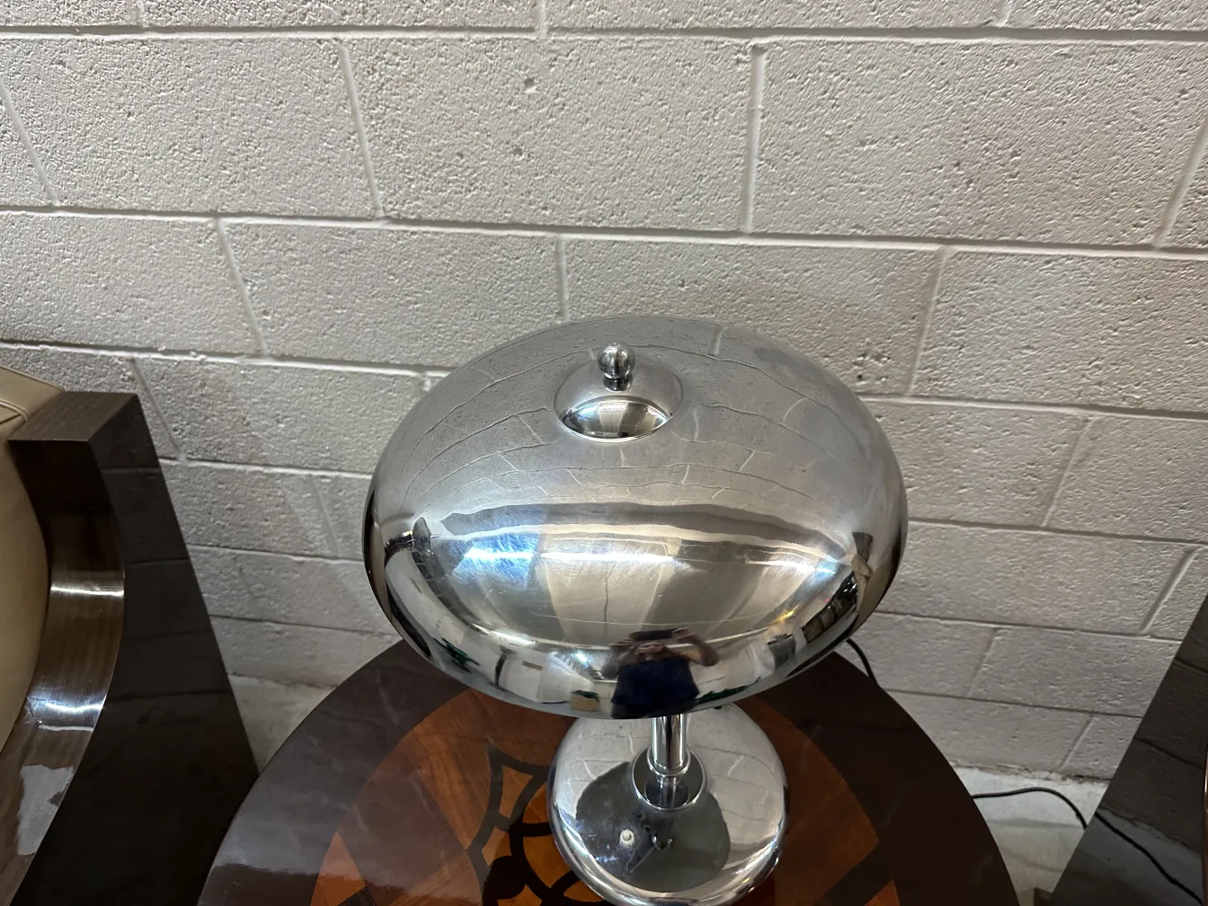 Lampada da tavolo antica con base sferica in un ambiente moderno. Brilla con una finitura luminosa.