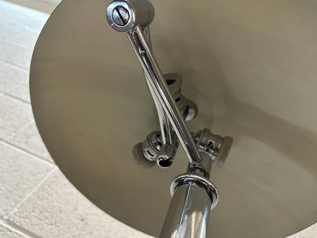 Lampada da tavolo antica con base lucida e dettagli morbidi in un ambiente illuminato.