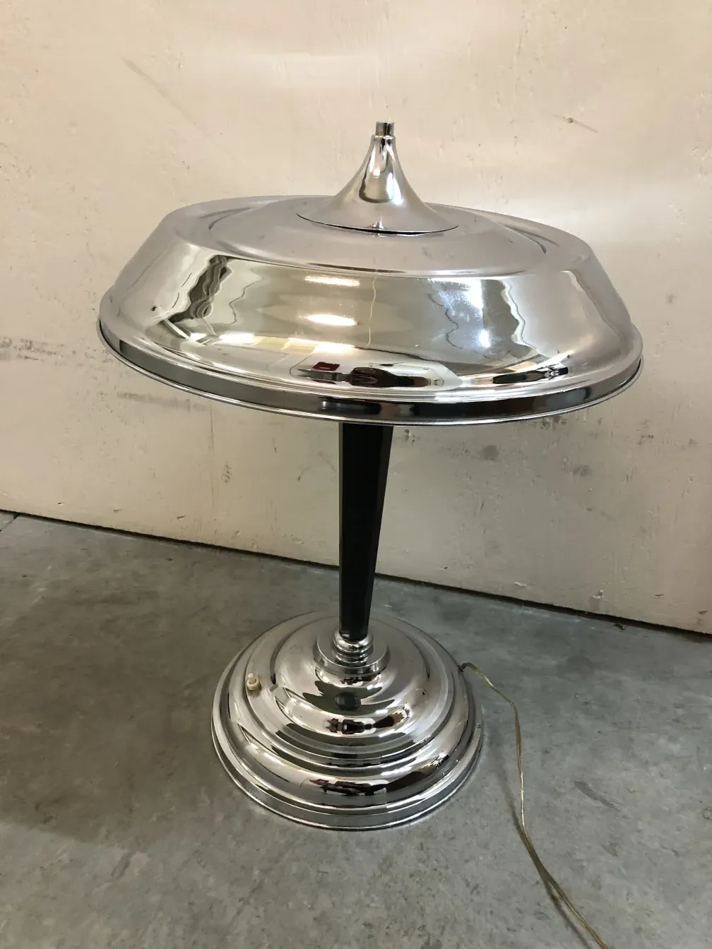 Antique table lamp with shiny shade, simple environment.