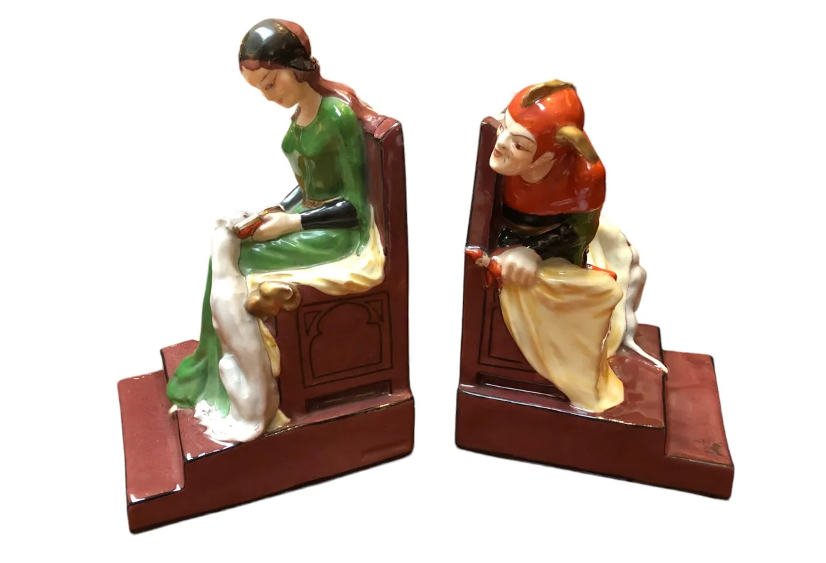 Apoyab libros antiguos con figuras en un fondo claro.